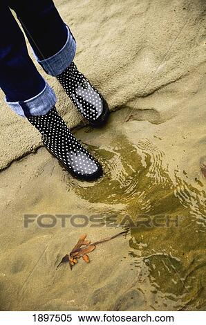 Stock Photography - a woman's rain boots reflected in the water; seattle, washington, united states of america. Fotosearch