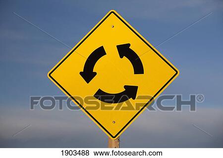 Stock Photo - a yellow traffic sign with three arrows going in a circle; calgary, alberta, canada. Fotosearch