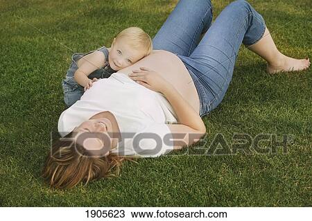 a young boy rests his head on his mother's pregnant belly; edmonton, alberta, canada View Large Photo Image Stock Image - a young boy rests his head on his mother's pregnant belly; edmonton, alberta, canada. Fotosearch
