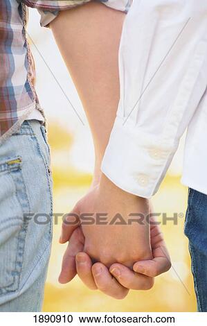 a young couple holding hands; wilmar, minnesota, united states of america View Large Photo Image Stock Image - a young couple holding hands; wilmar, minnesota, united states of america. Fotosearch