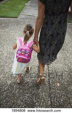 a young girl with a backpack walking hand in hand with her mother; palm beach, gold coast, queensland, australia View Large Photo Image Stock Photo - a young girl with a backpack walking hand in hand with her mother; palm beach, gold coast, queensland, australia. Fotosearch