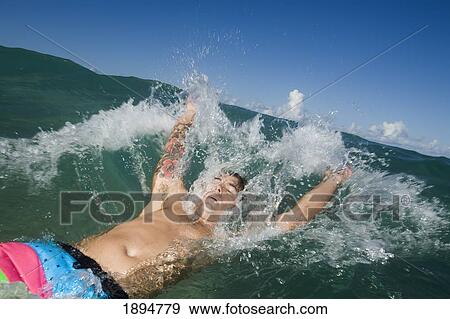 a young man laying on his back in the splashing water; gold coast, queensland, australia View Large Photo Image Stock Photo - a young man laying on his back in the splashing water; gold coast, queensland, australia. Fotosearch