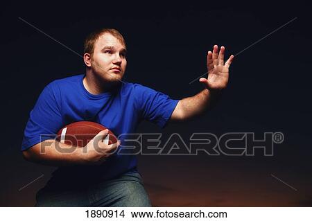 a young man playing football; wilmar, minnesota, united states of america View Large Photo Image Picture - a young man playing football; wilmar, minnesota, united states of america. Fotosearch