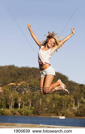 a young woman jumps in the air; currumbin, gold coast, queensland, australia View Large Photo Image Stock Photo - a young woman jumps in the air; currumbin, gold coast, queensland, australia. Fotosearch
