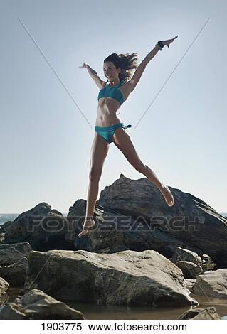 a young woman jumps off the rocks on bunker beach; tarifa, cadiz, andalusia, spain View Large Photo Image Stock Photography - a young woman jumps off the rocks on bunker beach; tarifa, cadiz, andalusia, spain. Fotosearch