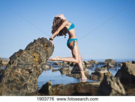 a young woman poses on the rocks on bunker beach; tarifa, cadiz, andalusia, spain View Large Photo Image Stock Photograph - a young woman poses on the rocks on bunker beach; tarifa, cadiz, andalusia, spain. Fotosearch