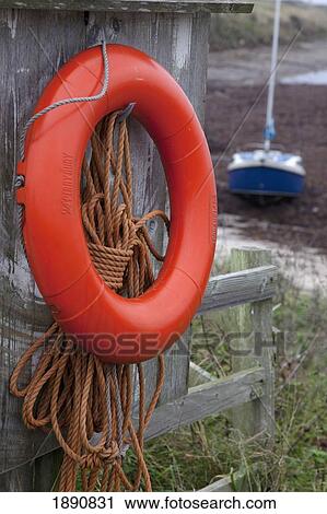 an orange life preserver ring and rope hanging on a wooden shed wall; northumberland, england View Large Photo Image Stock Image - an orange life preserver ring and rope hanging on a wooden shed wall; northumberland, england. Fotosearch