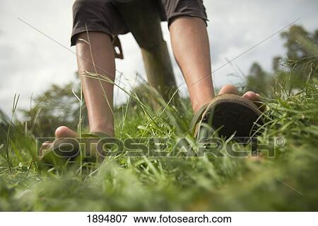 Stock Photo - bare legs and feet in sandals straddling a fence; byron bay, new south wales, australia. Fotosearch