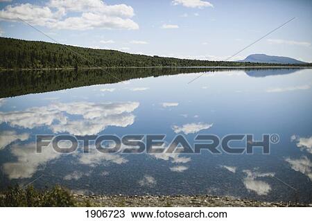 Stock Image - clouds reflected in the lake; vang, norway. Fotosearch