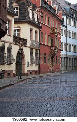 Stock Image - cobblestone street with colorful painted buildings; freiburg, germany. Fotosearch