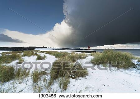 dark clouds and blue sky over a red lighthouse along the coast in the winter; south shields, tyne and wear, england View Large Photo Image Stock Photograph - dark clouds and blue sky over a red lighthouse along the coast in the winter; south shields, tyne and wear, england. Fotosearch