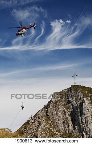 helicopter rescue on a mountain side with a cross on the top of the mountain; fussen, germany View Large Photo Image Stock Image - helicopter rescue on a mountain side with a cross on the top of the mountain; fussen, germany. Fotosearch