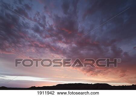 Stock Image - light of a sunset catches the clouds over the desert; arizona, united states of america. Fotosearch