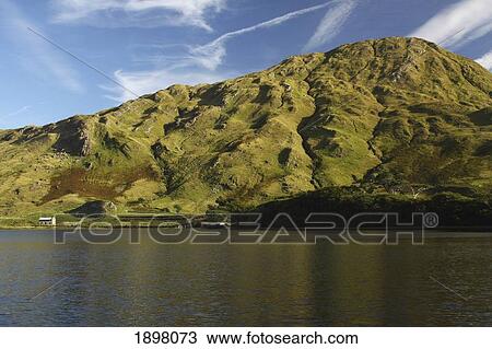 Stock Image - lone house on the side of kylemore lake in connacht region; connemara, county galway, ireland. Fotosearch