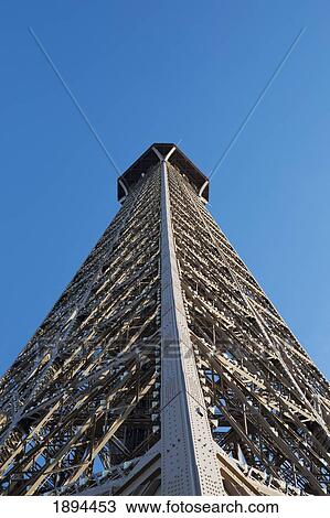 Stock Image - low angle of the eiffel tower against a blue sky; paris, france. Fotosearch