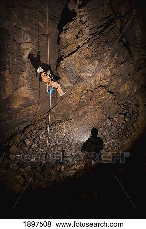 male athlete ascending a rope to exit a cave; fernie, british columbia, canada View Large Photo Image Stock Photo - male athlete ascending a rope to exit a cave; fernie, british columbia, canada. Fotosearch