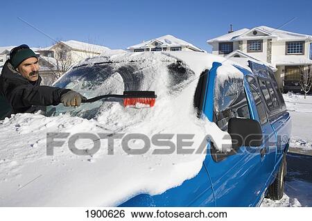 man brushing snow off a vehicle's windshield; calgary, alberta, canada View Large Photo Image Stock Photograph - man brushing snow off a vehicle's windshield; calgary, alberta, canada. Fotosearch
