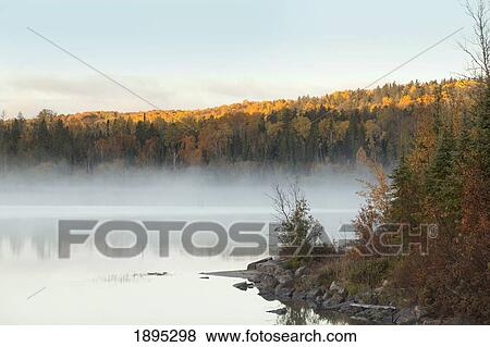 Stock Photo - mist over a lake in autumn near wawa; ontario, canada. Fotosearch