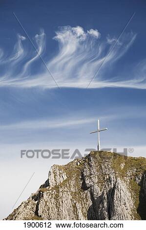 mountain peak with a cross on top against a blue sky with clouds; fussen, germany View Large Photo Image Stock Image - mountain peak with a cross on top against a blue sky with clouds; fussen, germany. Fotosearch