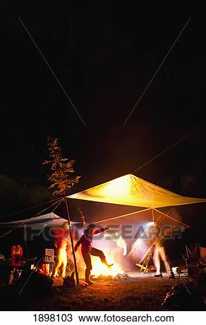 Stock Image - playing around the camp fire; fernie, british columbia, canada. Fotosearch