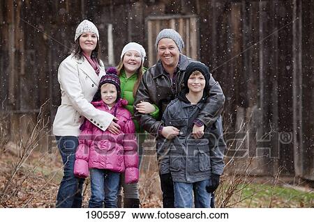 Stock Photo - portrait of a family in a snowfall; grimsby, ontario, canada. Fotosearch