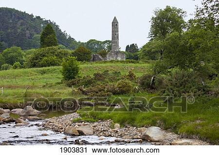 Stock Image - ruins of a building and a round tower on a 6th century monastic site; glendalough, county wicklow, ireland. Fotosearch