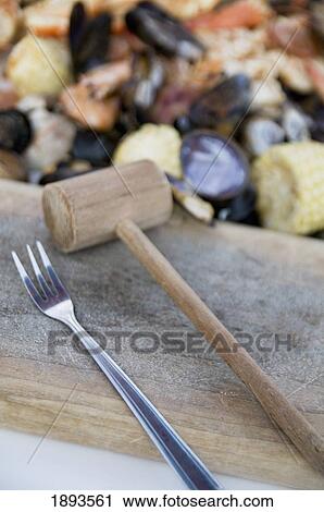 steamed seafood and a fork and mallet on a chopping block; seattle, washington, united states of america View Large Photo Image Stock Image - steamed seafood and a fork and mallet on a chopping block; seattle, washington, united states of america. Fotosearch