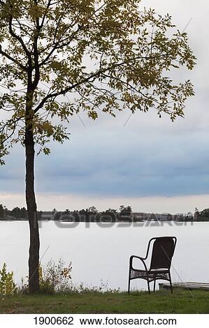 sunrise over a lake with a chair at the water's edge; ontario, canada View Large Photo Image Stock Image - sunrise over a lake with a chair at the water's edge; ontario, canada. Fotosearch