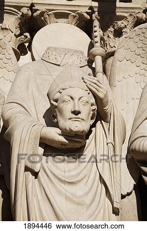 the statue of st. denis holding his head at the notre-dame cathedral; paris, france View Large Photo Image Stock Photograph - the statue of st. denis holding his head at the notre-dame cathedral; paris, france. Fotosearch