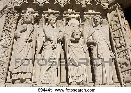 Stock Photography - the statues around st. denis holding his head at the notre-dame cathedral; paris, france. Fotosearch