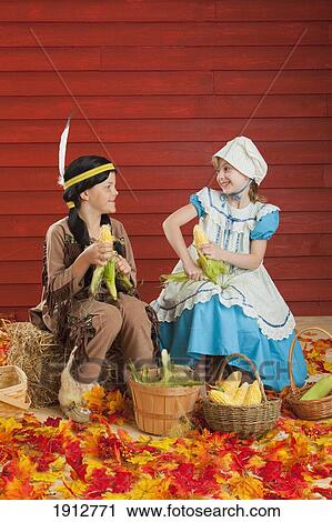 two children in costume husking corn to celebrate the harvest for thanksgiving; three hills, alberta, canada View Large Photo Image Stock Image - two children in costume husking corn to celebrate the harvest for thanksgiving; three hills, alberta, canada. Fotosearch