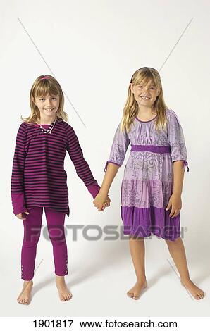 two girls wearing purple and holding hands View Large Photo Image Stock Photo - two girls wearing purple and holding hands. Fotosearch