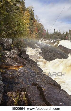 water flowing against the rocks in a river in autumn; ontario, canada View Large Photo Image Picture - water flowing against the rocks in a river in autumn; ontario, canada. Fotosearch