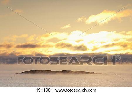 Stock Image - winter mist on lake superior at sunrise; terrace bay, ontario, canada. Fotosearch