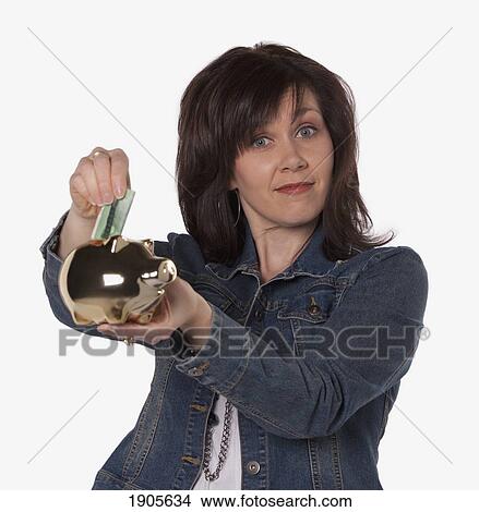 woman saving money in a piggy bank; edmonton, alberta, canada View Large Photo Image Picture - woman saving money in a piggy bank; edmonton, alberta, canada. Fotosearch