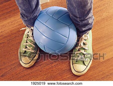 Stock Photo - a blue volleyball held between two feet. Fotosearch