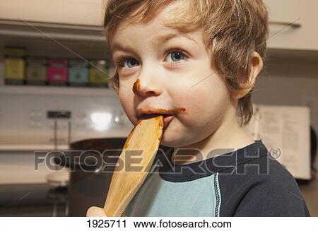a boy licking a spoon with chocolate on his face; langley, british columbia, canada View Large Photo Image Stock Image - a boy licking a spoon with chocolate on his face; langley, british columbia, canada. Fotosearch