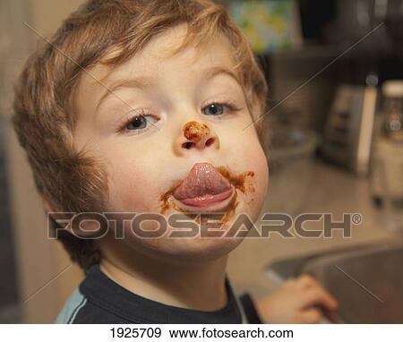 Stock Photo - a boy sampling homemade fudge; langley, british columbia, canada. Fotosearch