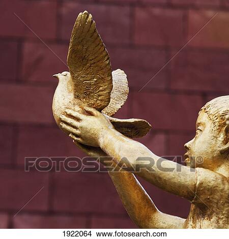 a gold statue of a child releasing a bird at the nagasaki atomic bomb museum; nagasaki, japan View Large Photo Image Picture - a gold statue of a child releasing a bird at the nagasaki atomic bomb museum; nagasaki, japan. Fotosearch