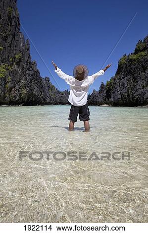 a man enjoys the sunshine and scenery in a small lagoon on miniloc island, near el nido; miniloc island, el nido, bacuit archipelago, palawan, philippines View Large Photo Image Picture - a man enjoys the sunshine and scenery in a small lagoon on miniloc island, near el nido; miniloc island, el nido, bacuit archipelago, palawan, philippines. Fotosearch