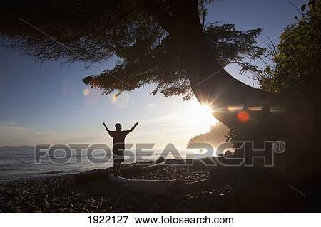 a man raises his arms at sunset; mystic beach, vancouver island, british columbia, canada View Large Photo Image Stock Photo - a man raises his arms at sunset; mystic beach, vancouver island, british columbia, canada. Fotosearch
