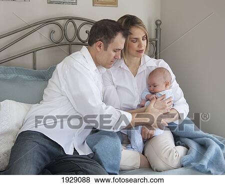 a mother and father praying with their baby on a bed; jordan, ontario, canada View Large Photo Image Stock Photo - a mother and father praying with their baby on a bed; jordan, ontario, canada. Fotosearch