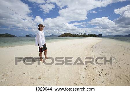 a tourist stands on the pure white sands of snake island, near el nido; bacuit archipelago, palawan, philippines View Large Photo Image Picture - a tourist stands on the pure white sands of snake island, near el nido; bacuit archipelago, palawan, philippines. Fotosearch