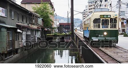 a train travels beside housing and a canal; nagasaki, japan View Large Photo Image Stock Image - a train travels beside housing and a canal; nagasaki, japan. Fotosearch