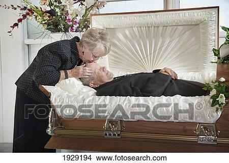 a woman kisses the head of her dead husband View Large Photo Image Picture - a woman kisses the head of her dead husband. Fotosearch