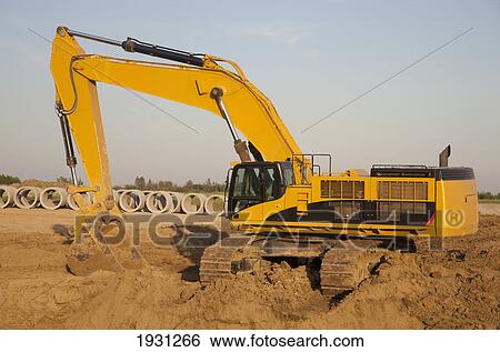 Stock Photograph - backhoe digging for sewer installation; st. albert, alberta, canada. Fotosearch