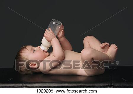 bare baby laying and drinking his bottle View Large Photo Image Stock Photography - bare baby laying and drinking his bottle. Fotosearch
