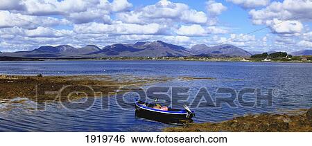 Boat With The Twelve Bens Mountain Range; Connemara, County Galway, Ireland View Large Photo Image Stock Photograph - Boat With The Twelve Bens Mountain Range; Connemara, County Galway, Ireland. Fotosearch