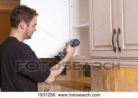 carpenter installing new kitchen cabinets View Large Photo Image Stock Photograph - carpenter installing new kitchen cabinets. Fotosearch