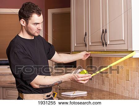 carpenter measuring and installing new kitchen cabinets View Large Photo Image Stock Photography - carpenter measuring and installing new kitchen cabinets. Fotosearch